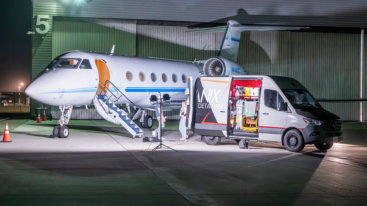Business jet and Lanix van outside the hangar at night, air-stair down