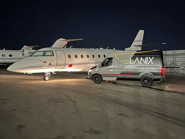 Aircraft detailed on the ramp at night beside the Lanix van
